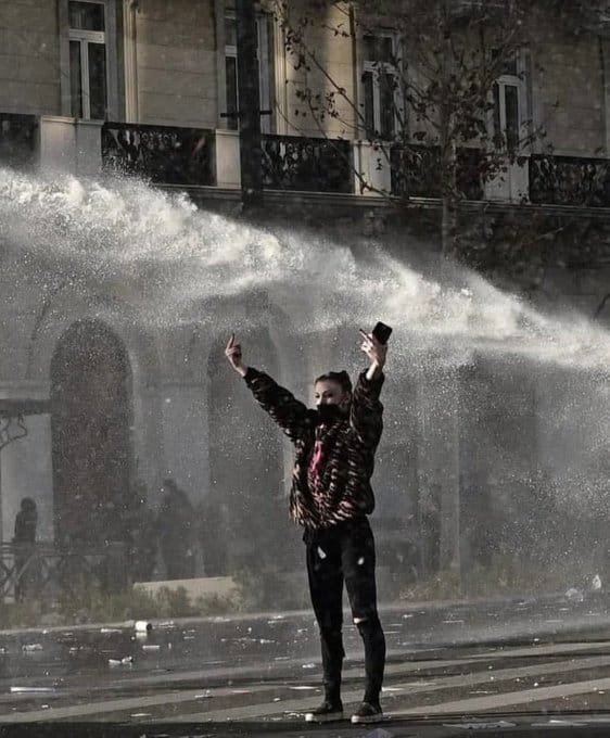 A 25-year-old woman from a respected business family, known for her education and charity work, stands fearlessly in front of a police water cannon during the Tempi protest in Syntagma Square, February 28, 2025